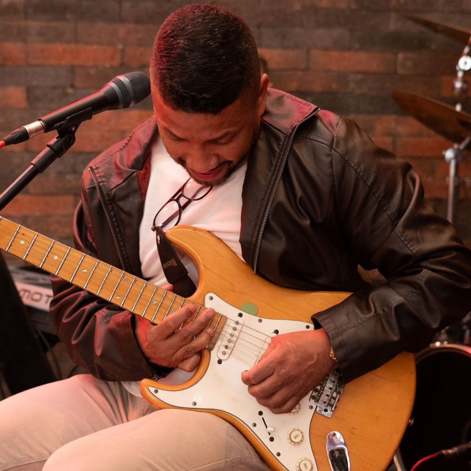 Léo Marcenes Músico ajustando guitarra em apresentação