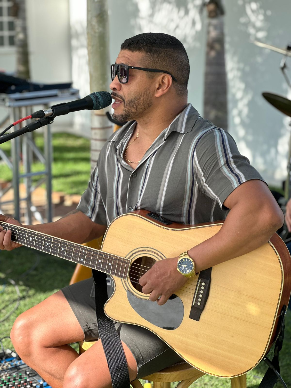 Léo Marcenes Cantor tocando violão em apresentação externa