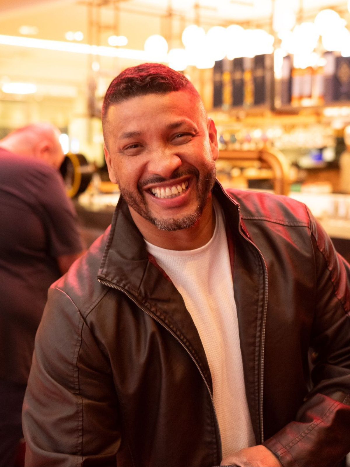 Léo Marcenes sorrindo em ambiente iluminado